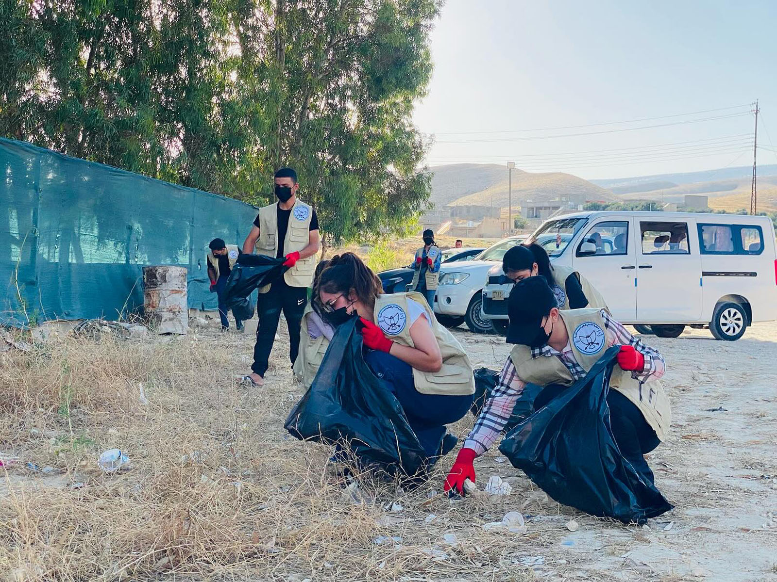 Volunteers and local families taking part in a tree planting activity in Sinjar